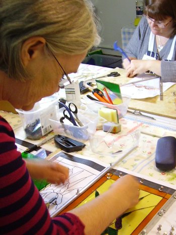 Vitreus Art improvers class working on copper foil stained glass panels